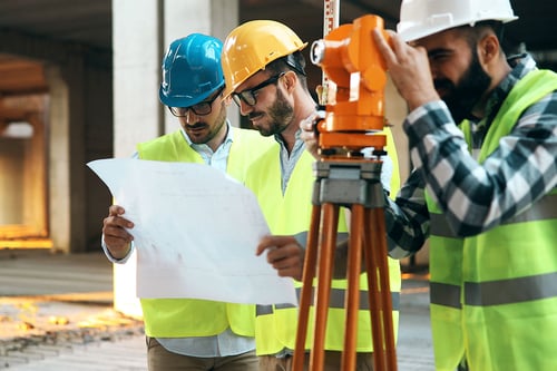 Surveyors looking at a blueprint on a worksite